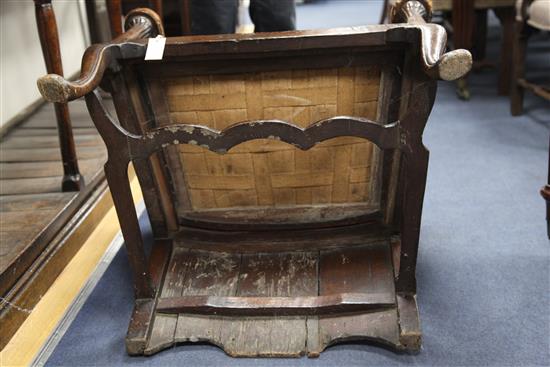 An 18th century boarded oak framed armchair,